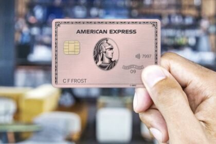 Bir American Express kartı tutan el