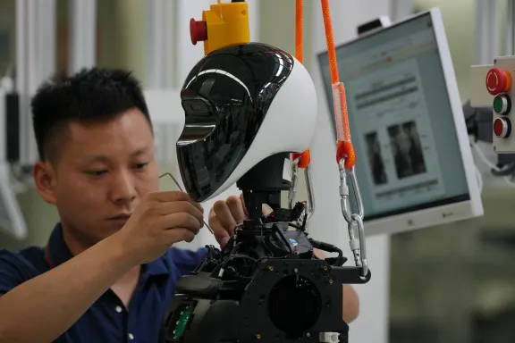 Pekin E-Town'da düzenlenen basın gezisi sırasında, işçiler LY iTech'in Pekin Süper Fabrikası'nda yapay zeka insansı robotunu monte eden bir işçi.