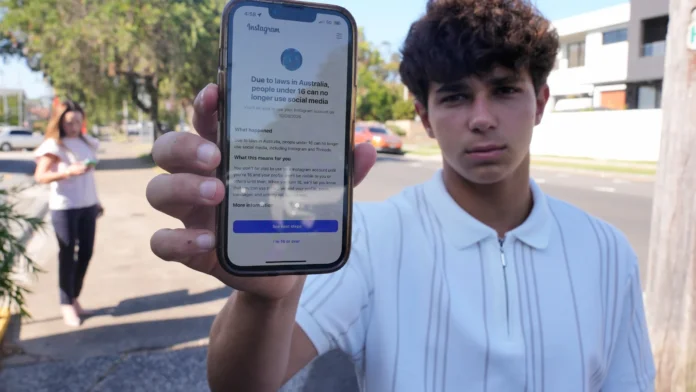 Avustralya’da bir genç, Instagram’ın 16 yaş altı erişim engeli bildirimini telefonunda gösteriyor